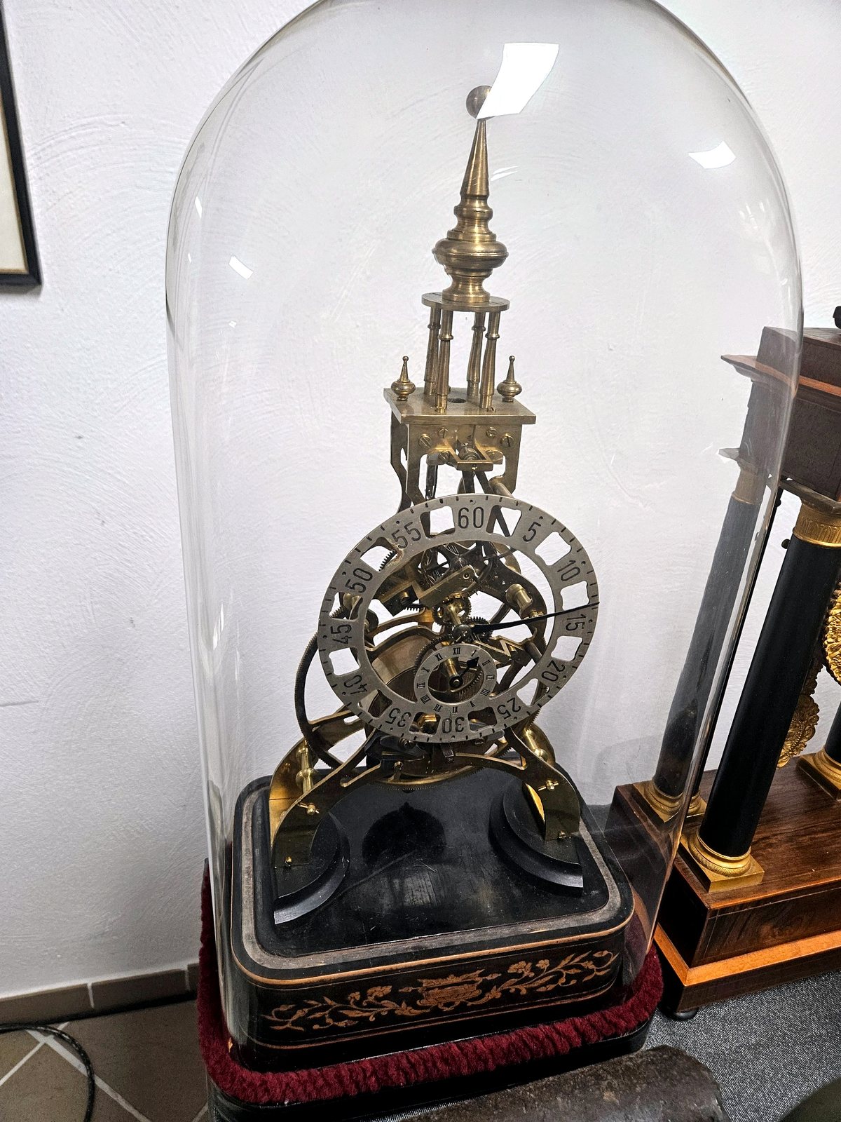 Englische Skelettuhr unter Glasdom mit offenem Messingwerk, Minutenring und schwarzem Sockel