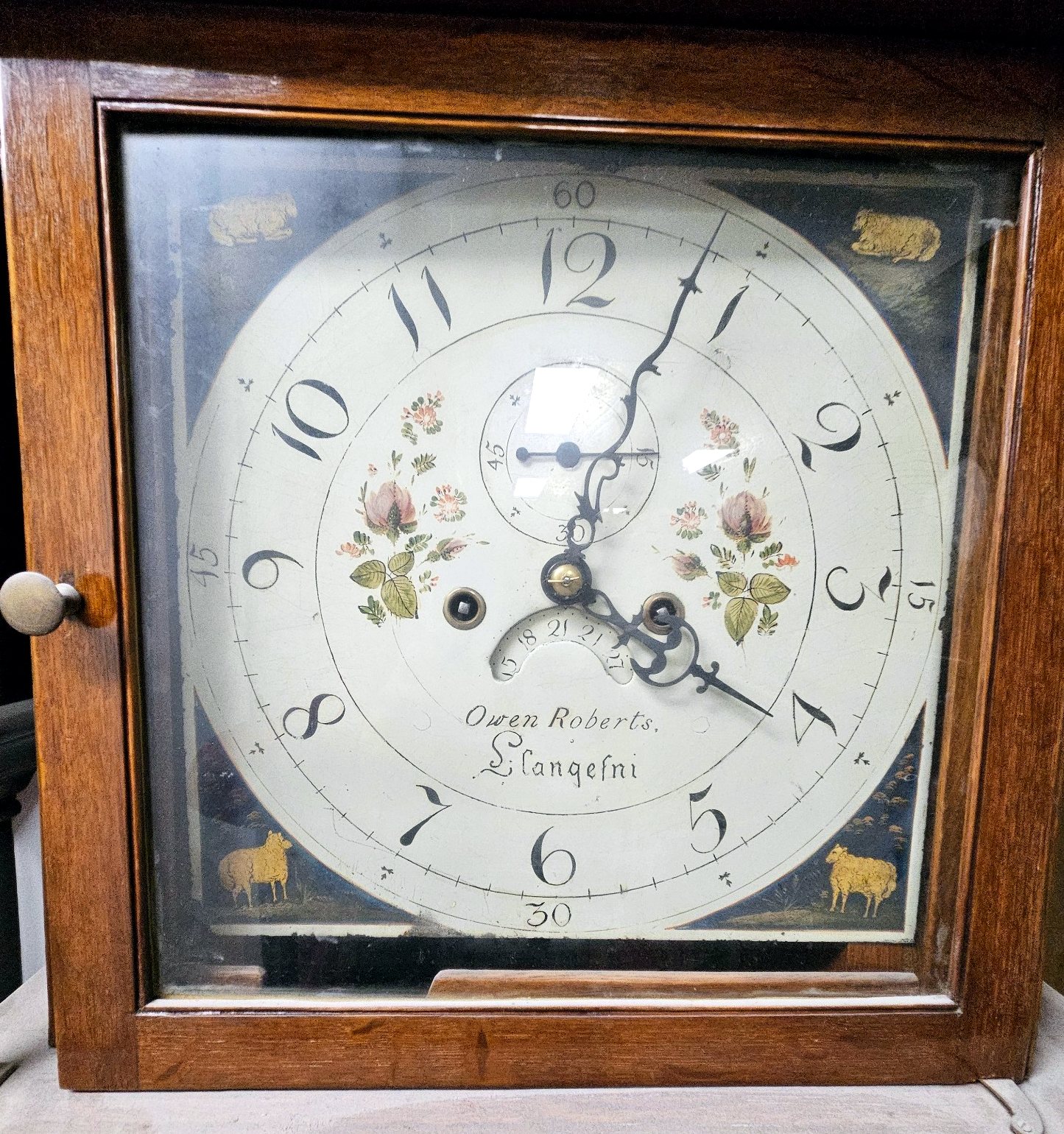 Bemaltes Zifferblatt der Standuhr mit Signatur Owen Roberts Llangefni, floralen Motiven und Schaf-Dekor