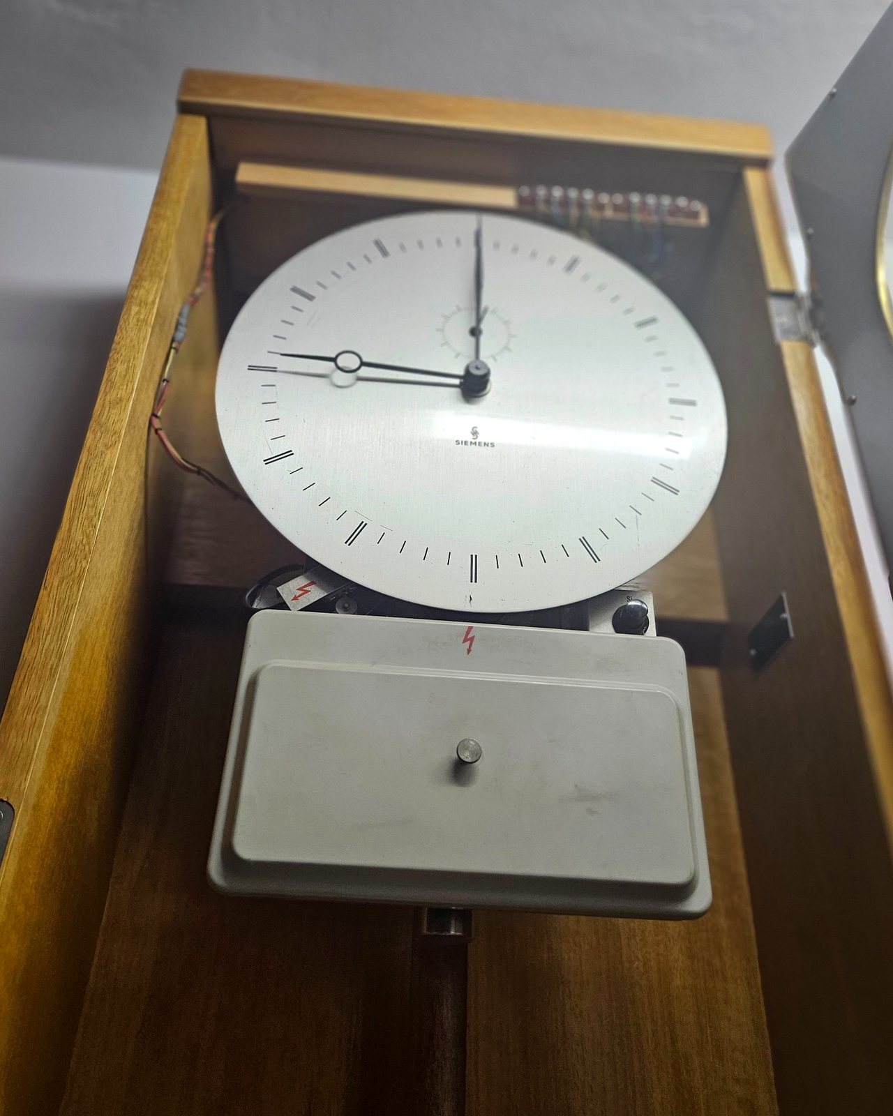 Geöffnete Siemens Mutteruhr mit Zifferblatt, Siemens-Signatur, Kontaktleiste und elektrischem Steuerkasten