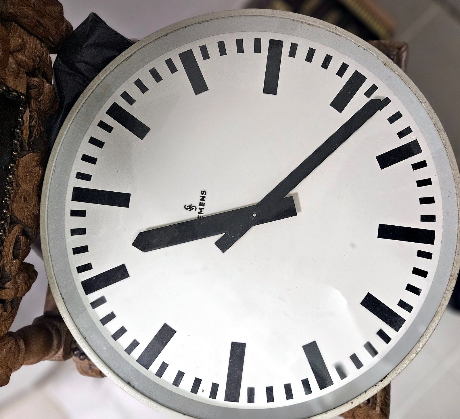 Siemens-Nebenuhr mit rundem Zifferblatt, schwarzen Strichmarkierungen und klarer Industriegestaltung.